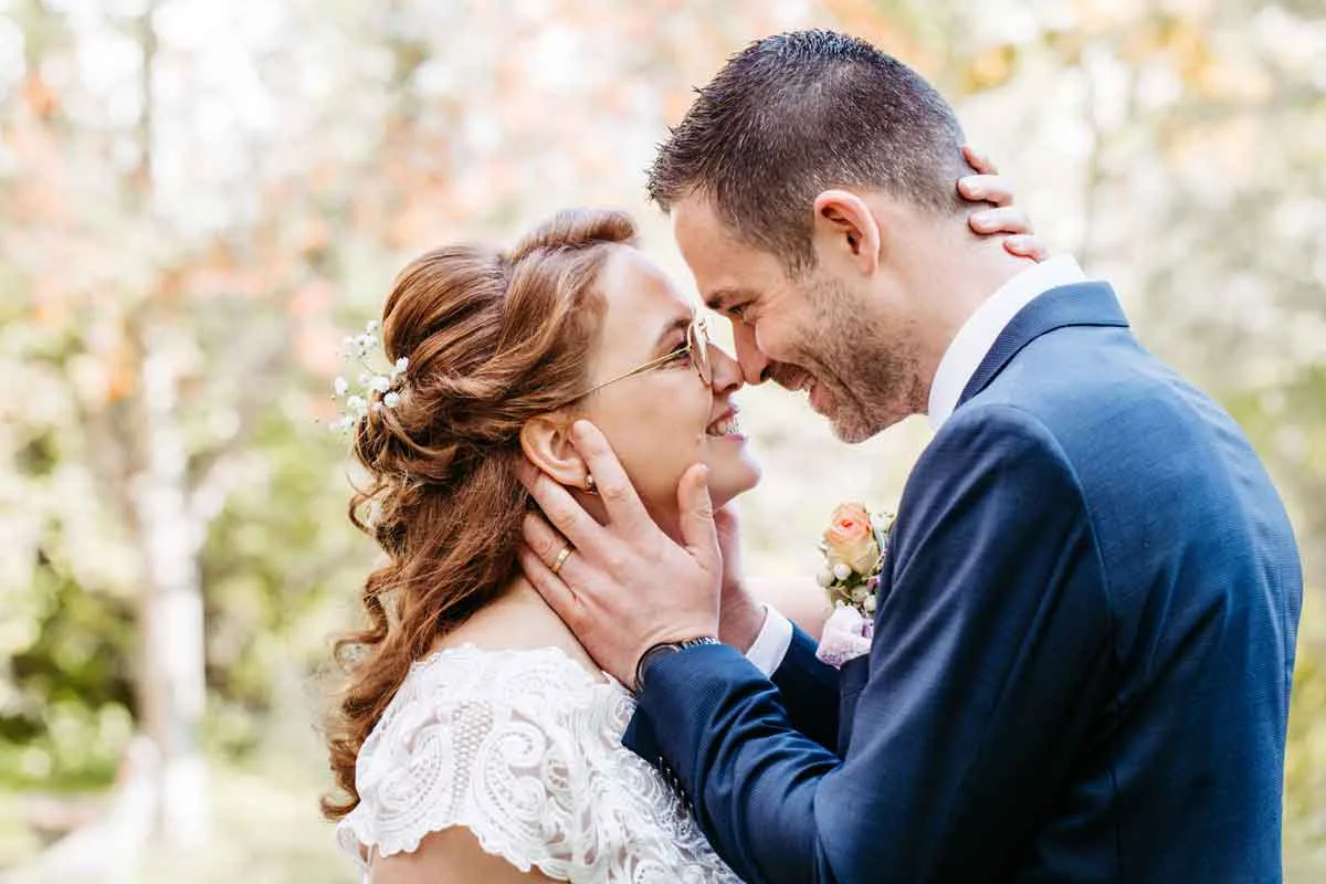 Das Brautpaar steht nah zusammen und sie lächeln sich an. Sie wollen sich gleich küssen. Der Hochzeitsfotograf Berlin hat sich bei diesem Bild für eine Nahaufnahme entschieden.