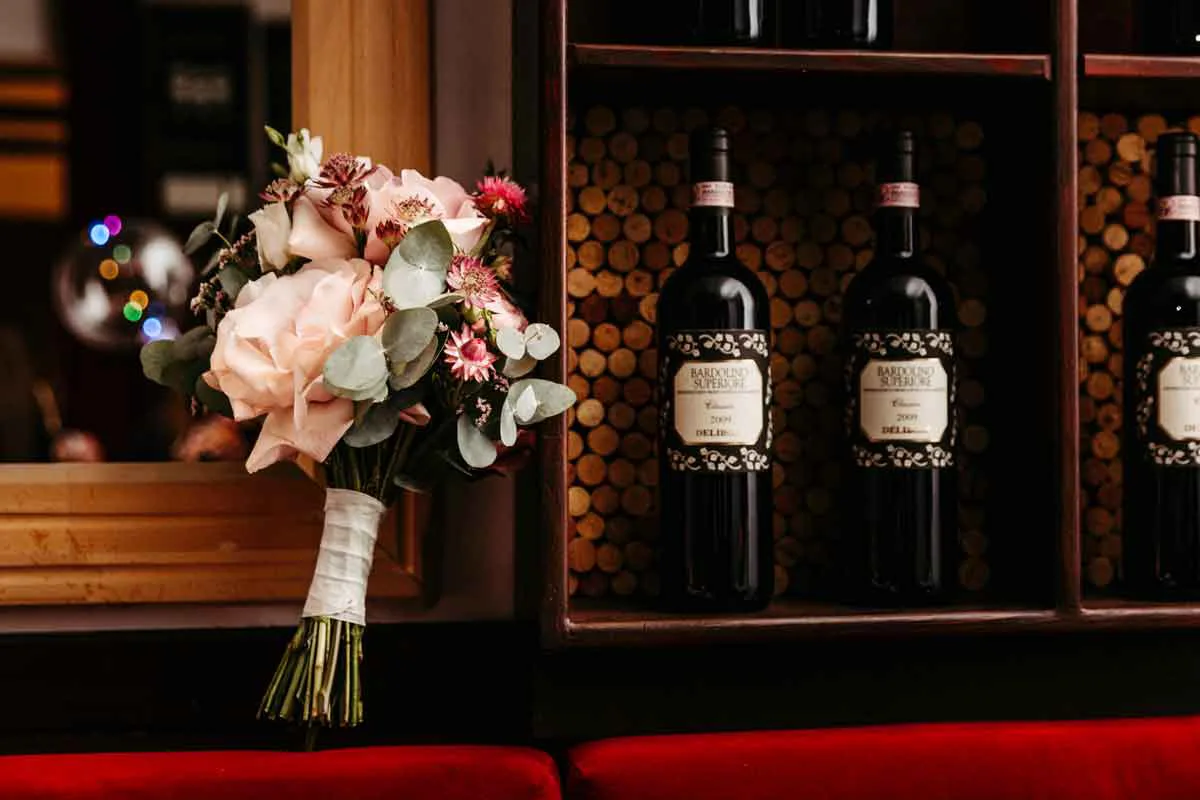 Brautstrauß neben dem Weinregal fotografiert.