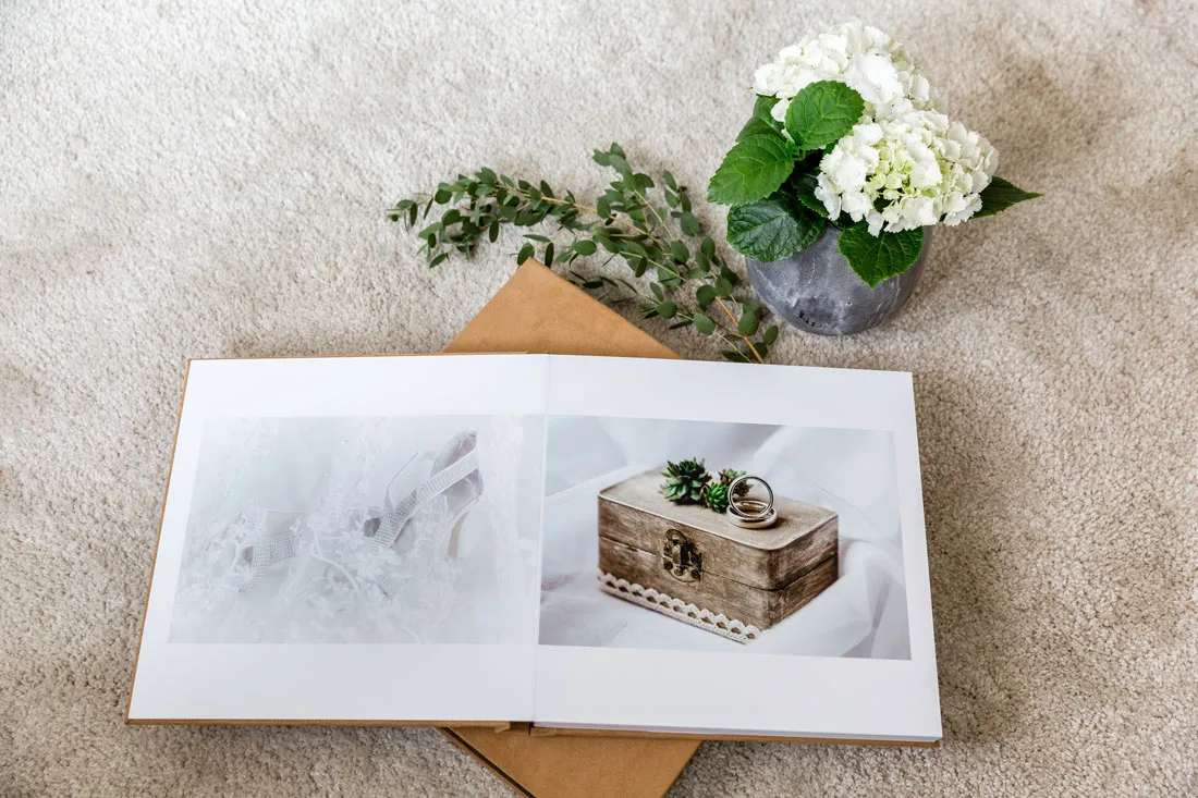 Detailaufnahme vom aufgeschlagenen Fotobuch. Die Blumen dienen als Dekoration.