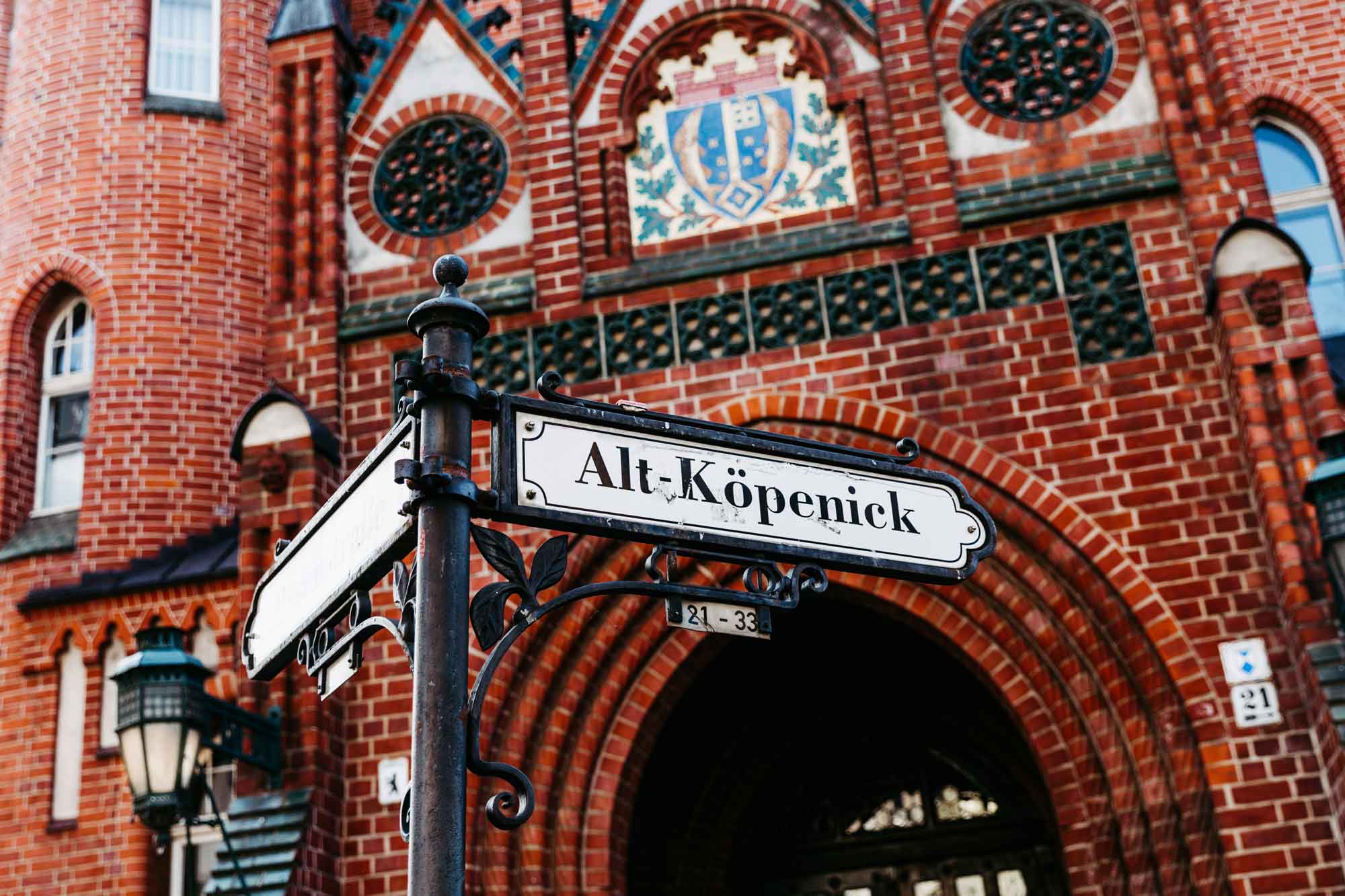 Aufnahme vom Eingang des Standesamtes Treptow Köpenick mit Straßenschild im Vordergrund.