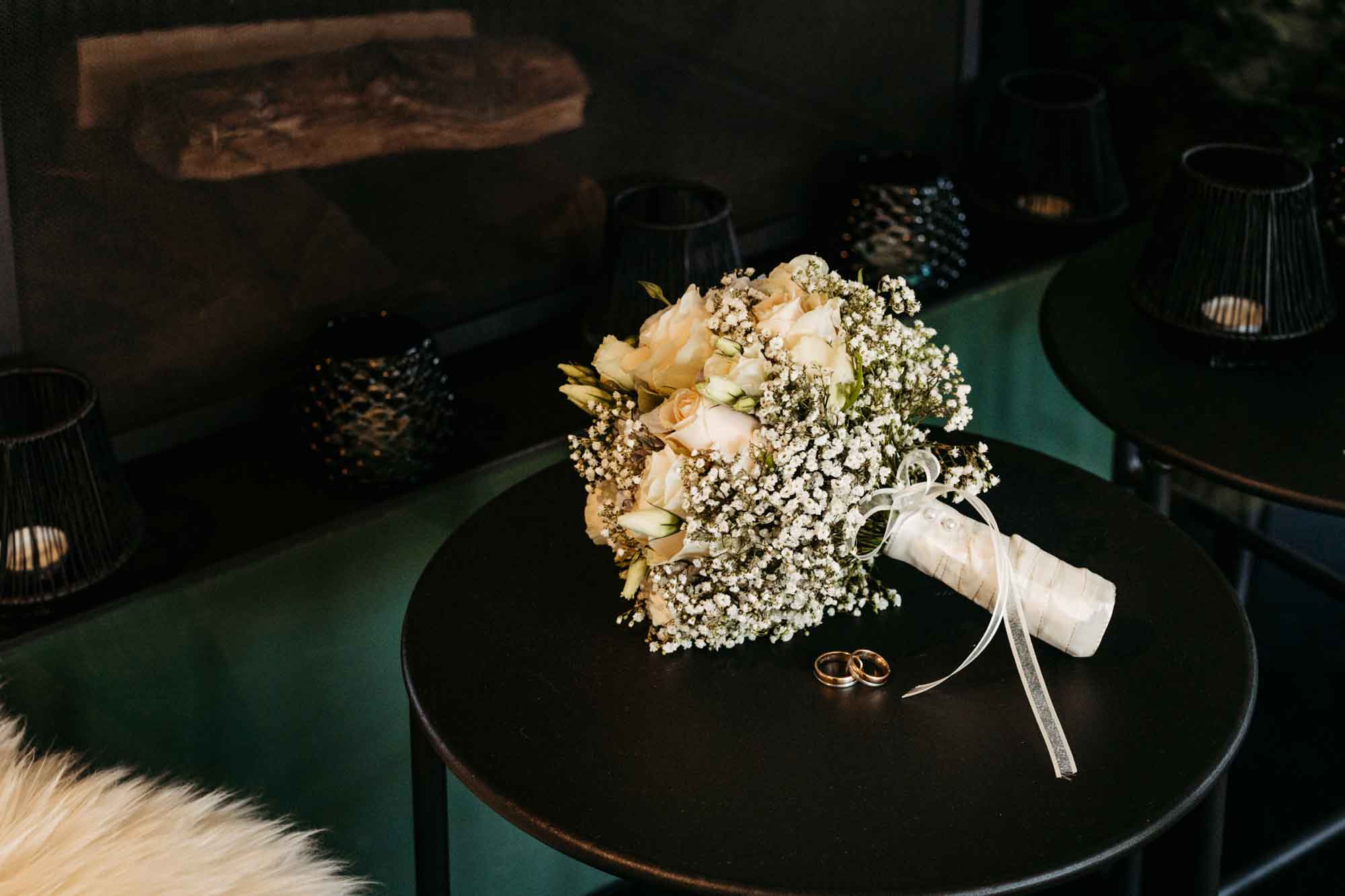 Der Brautstrauss liegt auf dem Tisch vor dem Kamin. Die Traunringe liegen vor dem Brautstrauss.